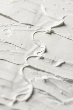 Artistic texture of white cosmetic cream on background