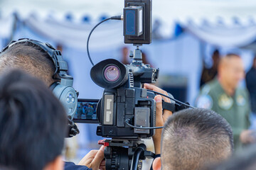A photographer is using a video camera to report the news.