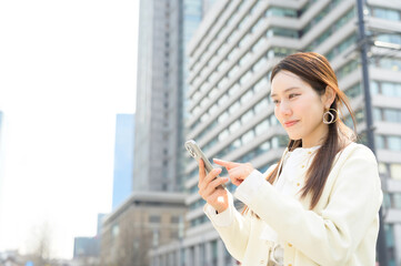 外光の中でスマートフォンを操作しながら穏やかな笑顔を見せる女性の姿が印象的
