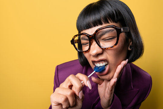 Latin young woman enjoying a lollipop with playful expression