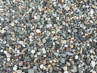 Natural pebble stone texture, top view of colorful smooth beach rocks background