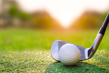 Close-Up of Golf Club and Golf Ball on Green Turf at Sunset