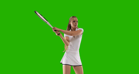 Woman tennis player playing tennis on green screen background.