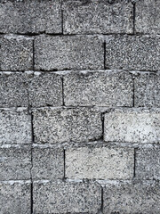 Vertical concrete block wall texture with rough surface and visible seams