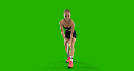 Woman tennis player playing tennis on green screen background.