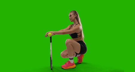 Woman tennis player playing tennis on green screen background.