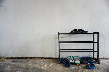 Sandals and Flip-flops on Metal Shoe Rack Against Wall