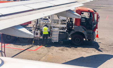 Refueling Airplane at Airport with Fuel Truck and Service Worker