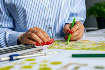 landscape architect, designer drawing ornamental garden plan in office