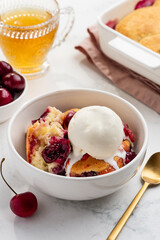 Cherry cobbler with a scoop of vanilla ice cream in a bowl. Selective focus