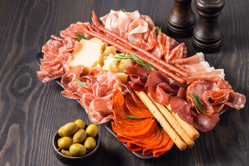 Charcuterie board. Antipasti appetizers of meat platter with salami, prosciutto crudo or jamon and...
