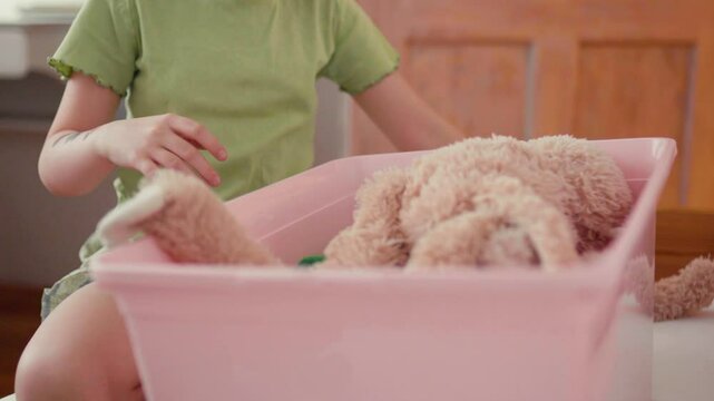 Child cleans up her toys.	

