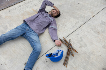 Worker lies on construction site floor with safety helmet suffer from accident