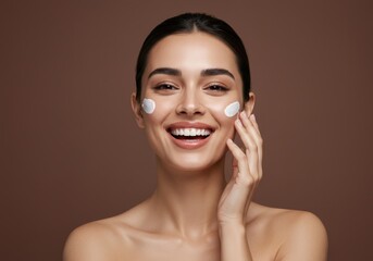 Happy woman applying facial moisturizer cream