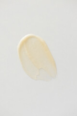 Vitamin C cream smear on white background. Minimal skincare beauty product texture, above vertical
