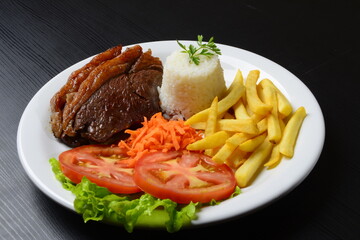 Picanha grelhada, servida com batatas fritas e salada