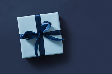 Blue gift box on navy blue background. Flat lay. Happy Fathers Day. Greeting card. View from above....