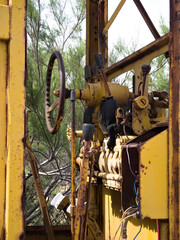 Rusty controls of an abandoned, agricultural machinery, rotting in a field.