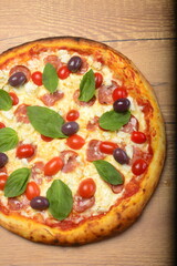 Pizza paulista, molho tomate, mozzarella, calabresa, tomate cereja, azeitonas pretas e manjericão