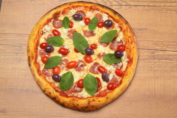 Pizza paulista, molho tomate, mozzarella, calabresa, tomate cereja, azeitonas pretas e manjericão