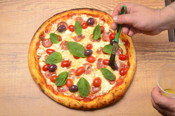 Pizza paulista, molho tomate, mozzarella, calabresa, tomate cereja, azeitonas pretas e manjericão