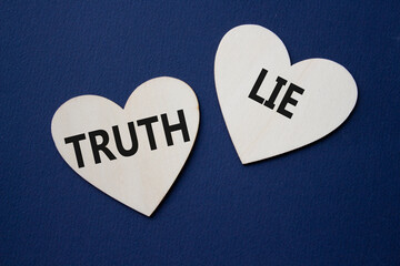 Truth or Lie symbol. Concept word Truth or Lie on wooden hearts. Beautiful deep blue background....