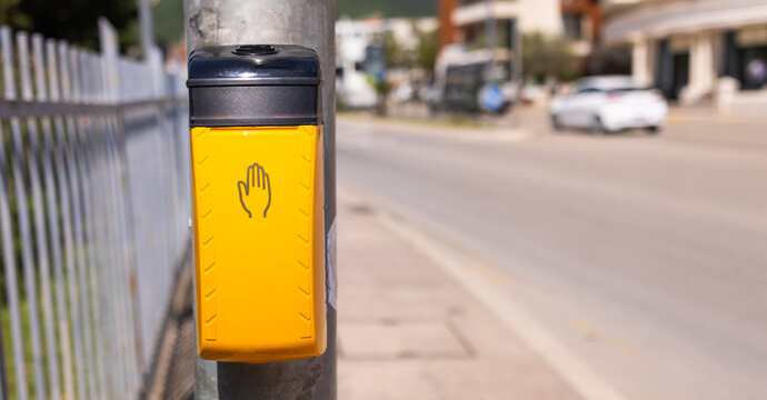 Pedestrian crossing button on sunny urban street. Urban navigation, road safety, and city transportation infrastructure. Copy space