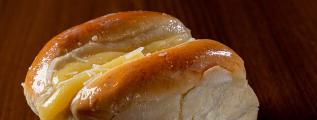 Sweet bread:
Sweet buns with vanilla cream on the brown wooden table and black background