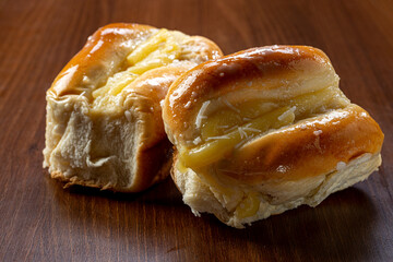 Sweet bread:
Sweet buns with vanilla cream on the brown wooden table and black background