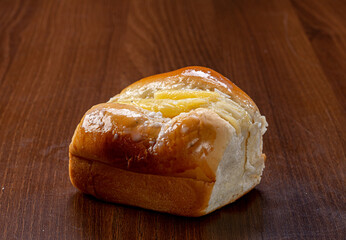Sweet bread:
Sweet buns with vanilla cream on the brown wooden table and black background