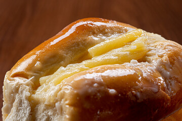 Sweet bread:
Sweet buns with vanilla cream on the brown wooden table and black background