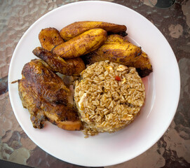 peruvian fried chicken dish with pork and egg fried rice fried sweet plantains and spicy green sauce (peru cuisine restaurant special meal ossining new york) white plate rotisserie pollo asian fusion