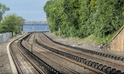 view down double train tracks on commuter rail line in upstate new york (travel commute rails track platform station stop) north metro subway