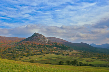 Expansive autumn landscape with rolling hills and distinctive peak.