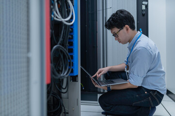 Computer engineer is setting up network in server room,Systems Maintenance Technician,Male engineer working in server room at modern data center