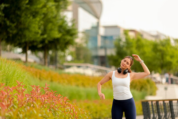 Woman enjoying music and movement in a vibrant urban park during a sunny afternoon