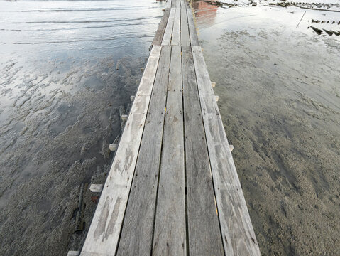 Weathered wooden jetty over low tide