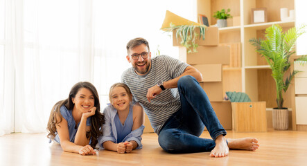 Family enjoys a sunny afternoon together in their new living room filled with boxes and greenery