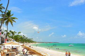 El Cortecito, Punta Cana, Dominican Republic- June 12, 2025: People walking along the coastline and sunbathing on one of the best beach in Caribbean area. Lots  of seaweed, specifically Sargassum.