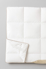Obraz premium White quilted blanket with folded corner 
