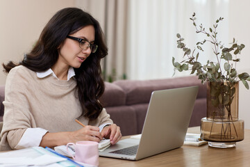 pretty woman working at home office, female worker using laptop computer for contact with clients online
