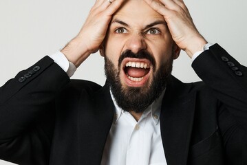 A frustrated businessman screams in despair, overwhelmed with stress and pressure.
