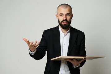 A professional man with a beard presents an idea, holding a tray and gesturing.