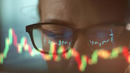Trader wearing glasses is working on laptop computer. Screen with stock market charts and Bitcoin BTC or Ethereum ETH data analysis reflection. Broker trading online. Altcoins crypto currency trading - Powered by Adobe
