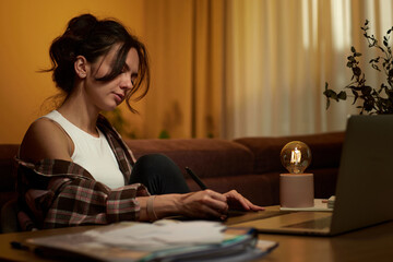 beautiful graphic designer woman working at home office remotely using digital graphic tablet and...