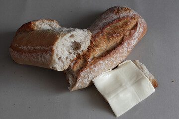A broken baked baguette with melted cheese.