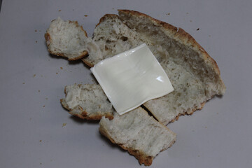 A broken baked baguette with melted cheese.