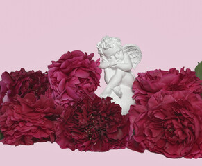 A white angel with wings sits on burgundy peonies, on a pink background.