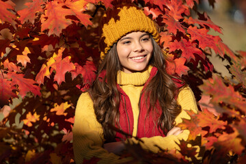Autumn teen child portrait. happy child in hat standing at autumn leaves. fall season