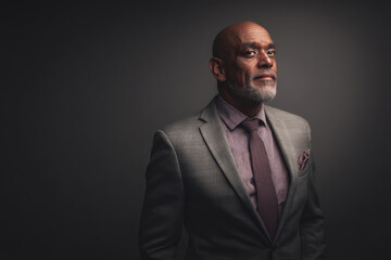 Fototapeta premium Confident Father in Modern Suit Against Gray Background